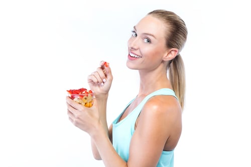 beautiful-young-woman-eating-cereals-fruits-white-background